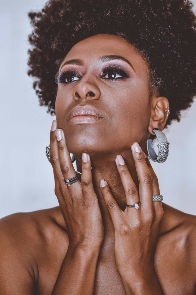 woman wearing ear-rings and several rings