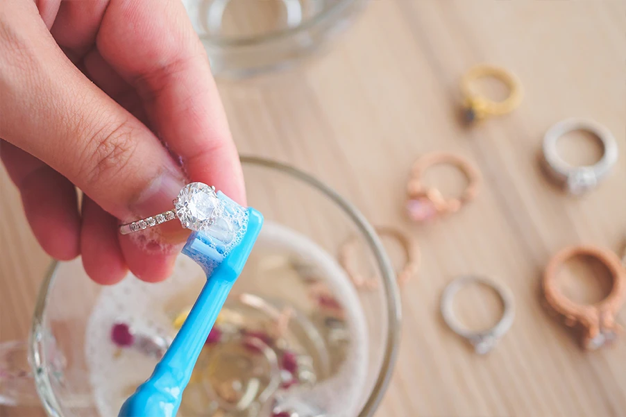 a hand brushing the stainless steel jewelry